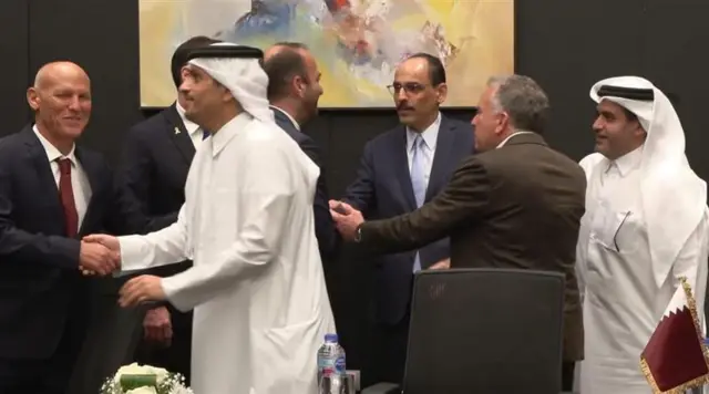 Several men from the Gaza peace talks sile and shake hands in Sharm El Sheikh, Egypt