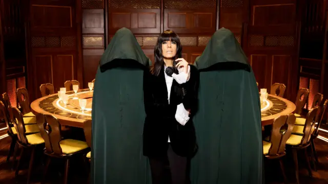 Claudia Winkleman and two cloaked traitors in the promotional shot for the traitors season three