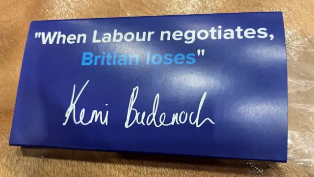 Blue chocolate bar wrapping which reads: "When Labour negotiates, Britian loses". Kemi Badenoch signature underneath slogan.