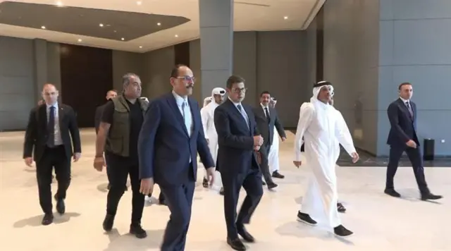 Palestinian and Qatari officials walk together inside a venue in Sharm El Sheikh, Egypt