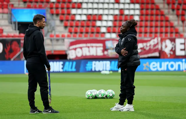 : Sandy Baltimore of Chelsea talks with a member of the Chelsea backroom staff prior to the UEFA Women's Champions League 2025/26 league phase match between FC Twente and Chelsea FC Women at De Grolsch Veste on October 08, 2025 in Hengelo, Netherlands