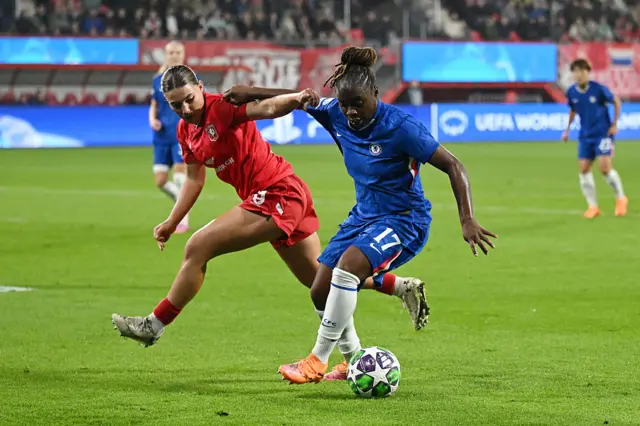 Sandy Baltimore of Chelsea controls the ball under pressure from Lynn Groenewegen of FC Twente during the UEFA Women's Champions League 2025/26 league phase match between FC Twente and Chelsea FC Women at De Grolsch Veste