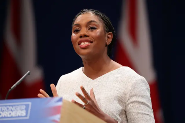 Kemi Badenoch standing behind a podium