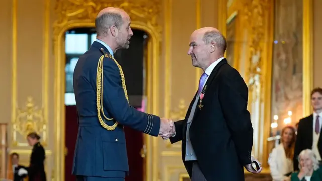 Prince of Wales (left) shaking the hand of Stephen Lambert (right).