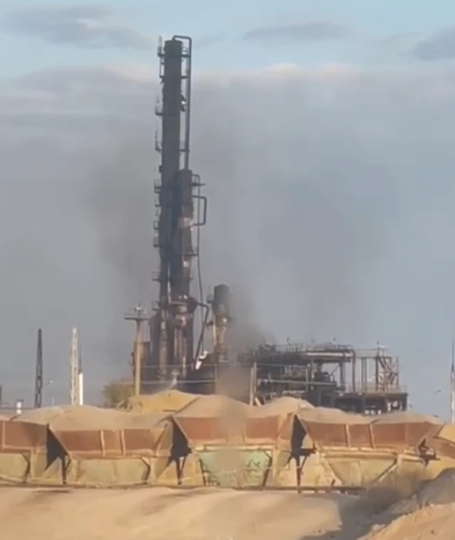 A chimney with heavy fire damage, large troughs of sand and a sandy pit are visible in the foreground
