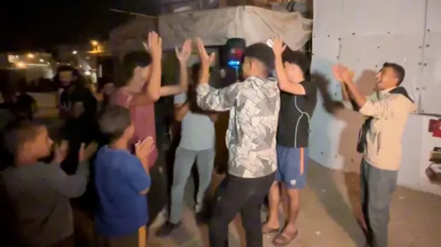 Group of young men with hands raised in celebration