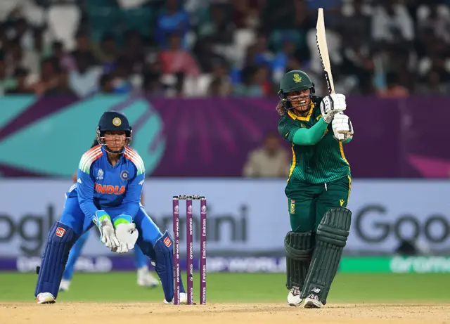 Chloe Tryon of South Africa bats as wicket keeper Richa Ghosh