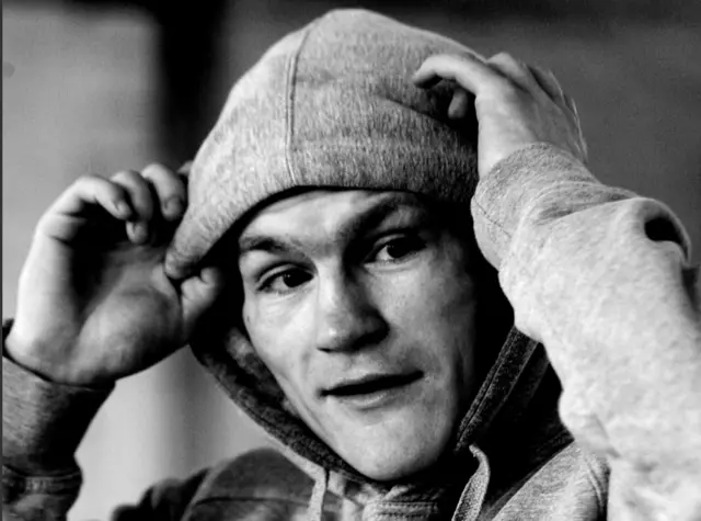 Ricky Hatton is wearing his hood up and and his hands on his head in this candid black and white shot