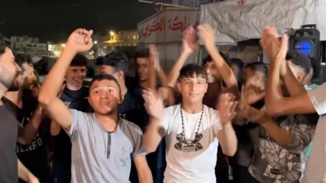 Group of young men with hands raised in celebration