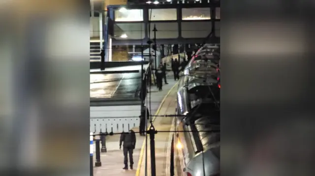 Police are seen running up the platform