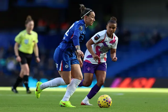 Lucy Bronze of Chelsea runs with the ball whilst under pressure from Nikita Parris
