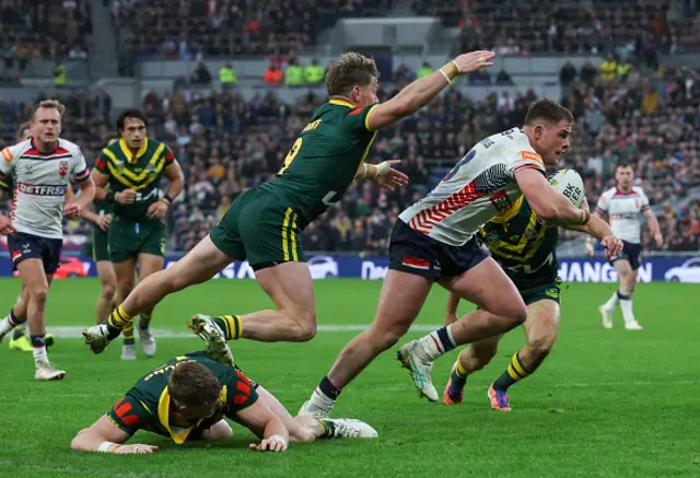 England's Morgan Knowles breaks through a tackle from Australia's Hudson Young with Harry Grant close by