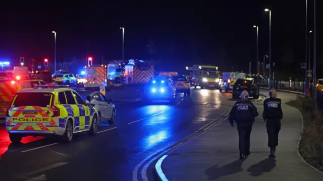 Emergency vehicles and police officers at the scene at Huntingdon train station in Cambridgeshire, after a number of people were stabbed on a train.