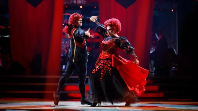 La Voix and Aljaz are dressed as the Queen and King of Hearts - respectively - and they strike dramatic poses with their hands spread out, and their faces turned away from one another