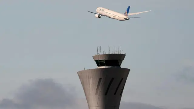 Plane flies over an air traffic control tower