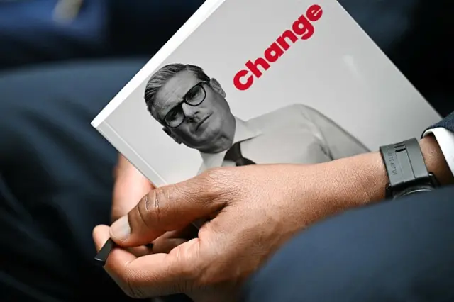 A member of the public holds the Labour Party election manifesto booklet during its launching, in Manchester