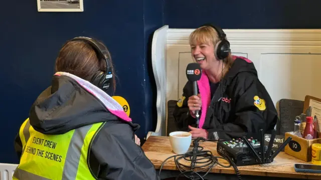 Sara and Clare laugh into radio microphones