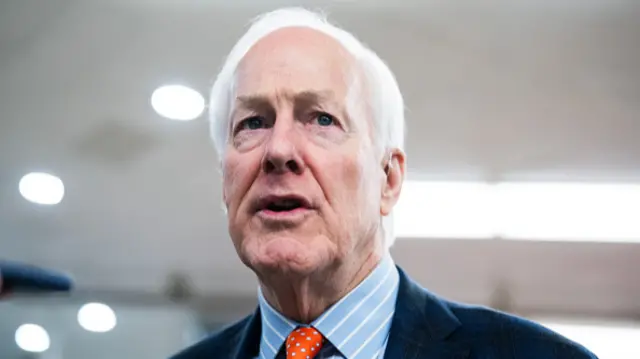 Republican Senator John Cornyn, of Texas, on 23 October 2025 in a suit, blue shirt and bright orange spotted tie.
