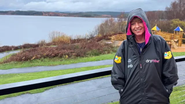 A smiling Sara stood in Kielder Forest.