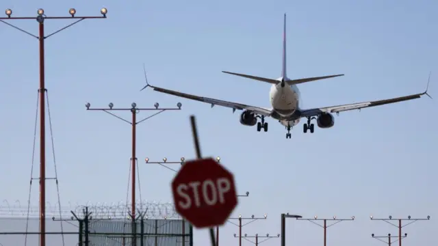 Plane flies over a stop sign