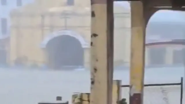 A distinctive yellow church in the background of a video showing flooding in the town of Virac, Philipppines