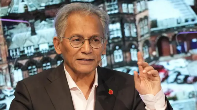 BBC chair Samir Shah raises his left hand as he talks