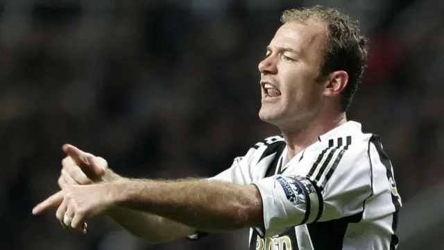 Alan Shearer, playing for Newcastle, points to his hand
