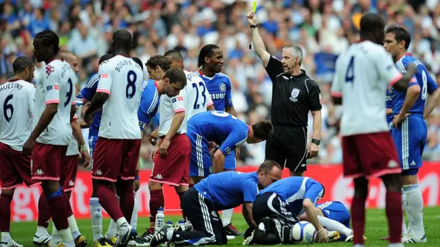Chris Foy shows a yellow card during the 2010 FA Cup final