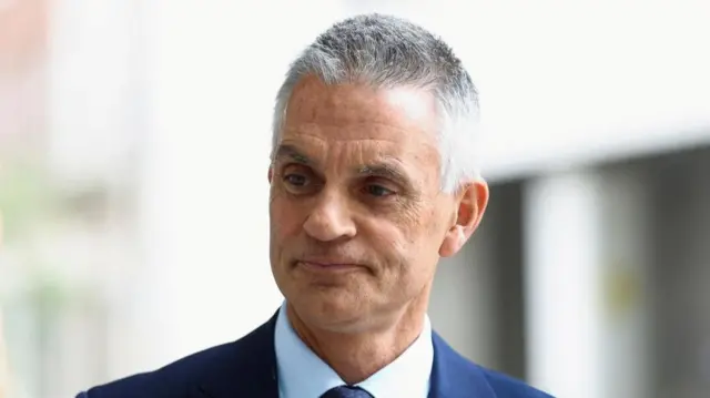 Tim Davie head and shoulder shot in front of a blurred backrground