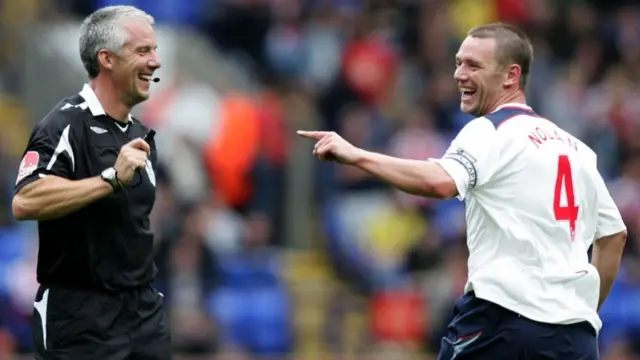 Kevin Nolan of Bolton jokes with referee Chris Foy