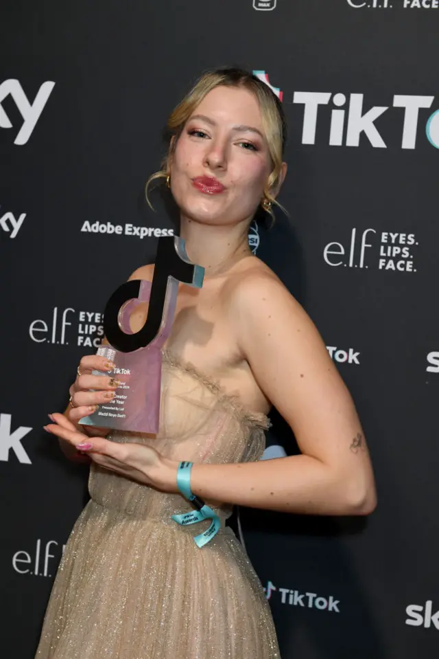 Maddi Neye-Swift holding her TikTok award on the red carpet