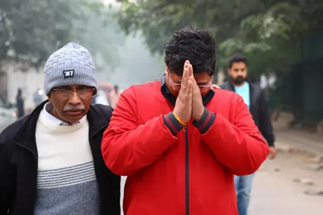 general Grieving families comfort each other as they gather outside a morgue in Delhi