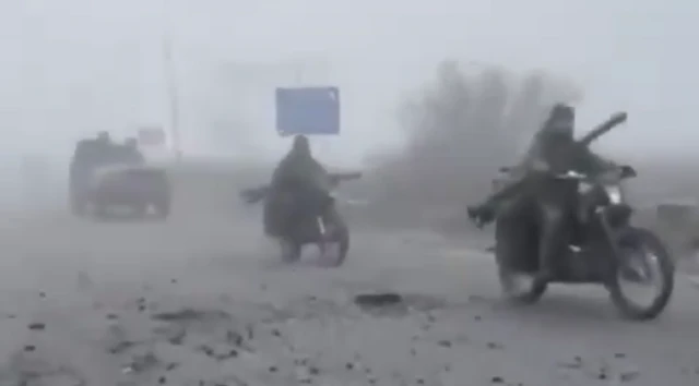 A screengrab from a video posted on Telegram showing two Russian soldiers on motorbikes followed by a jeep-type car