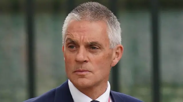 Tim Davie wearing a suit and white shirt