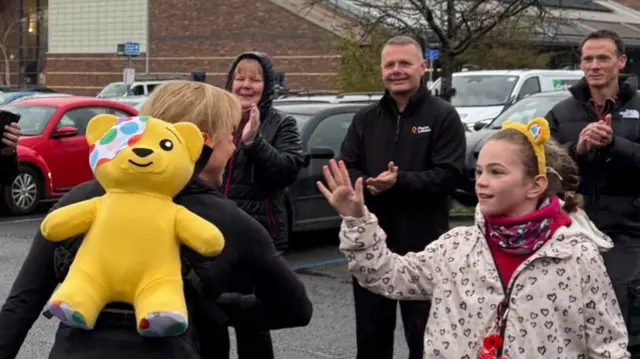 Sara and Pudsey high-five a supporter in Hexham
