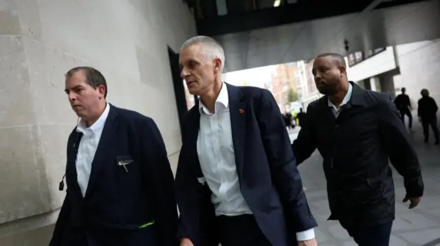 Tim Davie walks into Broadcasting House flanked by two security guards