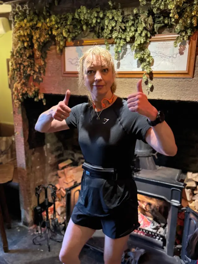 Sara gives a thumbs up as she dries off