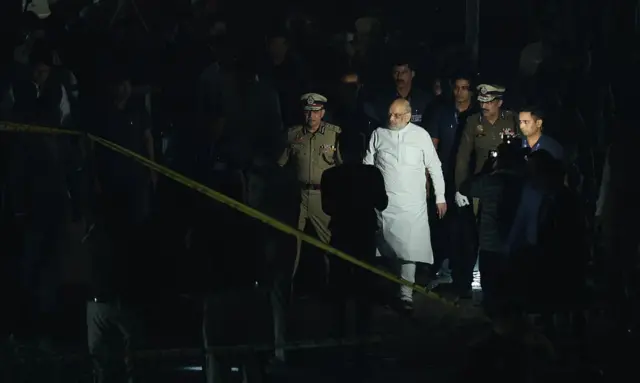 general Indian minister Amit Shah flanked by security guards visiting the blast site at night