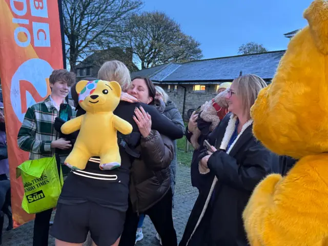 Sara and Pudsey hug it out with a supportive member of the public
