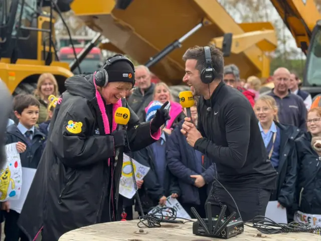 Sara and Gethin laugh into radio microphones