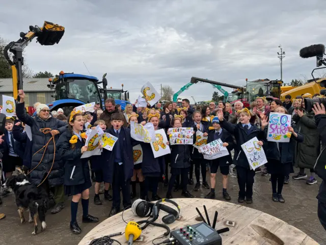 Supporters gather to Sara Cox in amongst a parade of tractors.