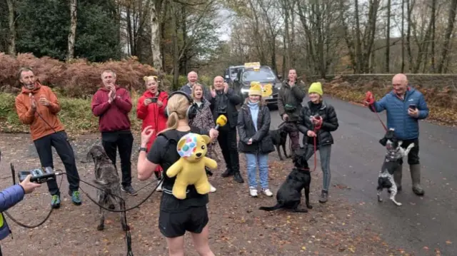 Sara awaits her new total with supporters and dogs
