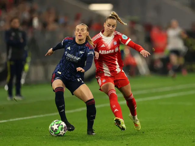 Chloe Kelly of Arsenal is challenged by Giulia Gwinn of Bayern Munich