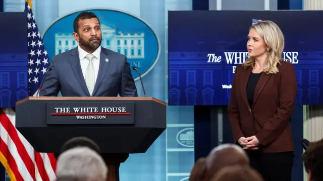 FBI Director Kash Patel speaks at the White House podium as Karoline Leavitt looks on