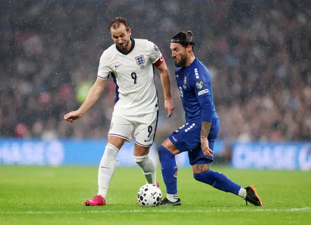 Harry Kane of England is challenged by Nemanja Gudeljof