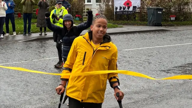 Jude comes through his finish line in a yellow coat