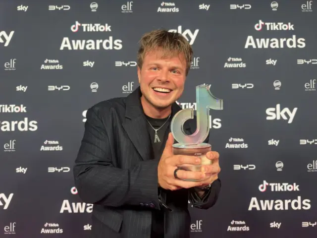 Max Klymenko holding his TikTok award