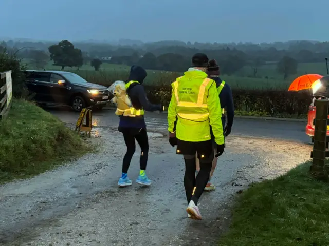 Sara and her team walking out towards the road