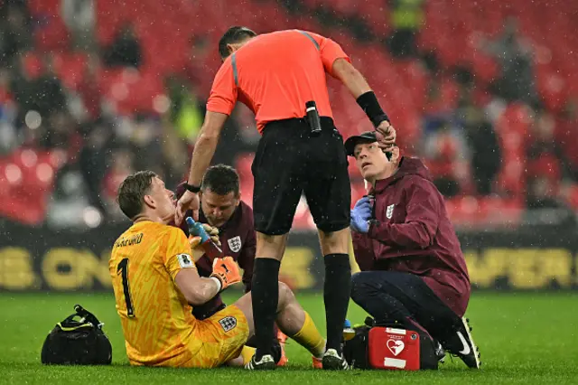 England's goalkeeper Jordan Pickford receives medical treatment