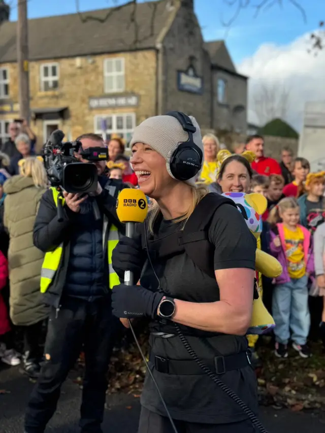 Sara beams into a radio mic